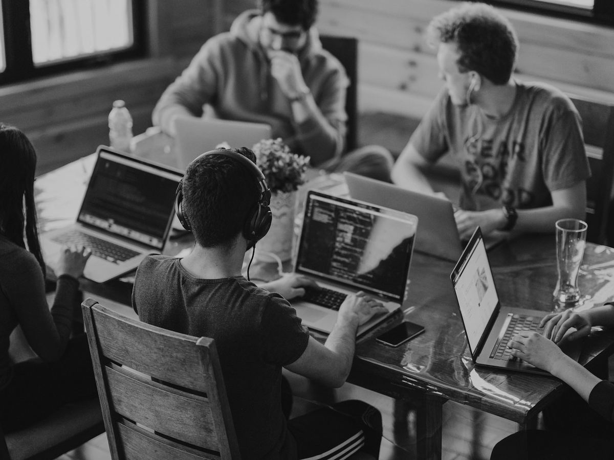 Team arbeitet gemeinsam an Laptops